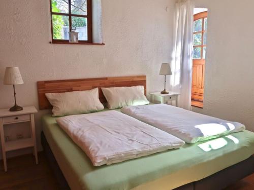een slaapkamer met een groot bed met 2 tafels en een raam bij Apartment in Geiersthal in Weilmünster
