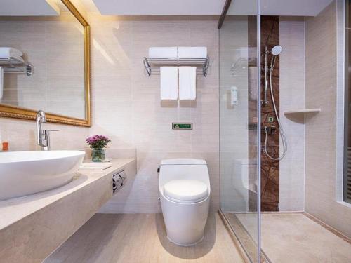 a bathroom with a toilet and a sink and a shower at Vienna Hotel Xuzhou Junsheng Plaza Benteng Avenue Metro Station in Xuzhou