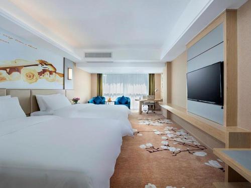 Cette chambre comprend 2 lits et une télévision à écran plat. dans l'établissement Vienna Hotel Fuzhou Changle Shouzhan Hangcheng Metro Station, à Changle