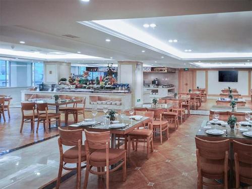 um restaurante com mesas e cadeiras e uma cozinha em Venus International Hotel Guangdong Huizhou West Lake em Huizhou