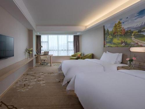 Habitación de hotel con cama grande y TV en Venus International Hotel Guangdong Huizhou West Lake, en Huizhou