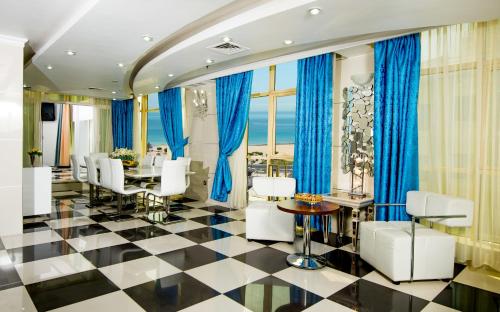 a dining room with blue curtains and a table and chairs at Bravo Royal Hotel Suites in Kuwait