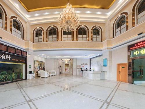 a large lobby with a chandelier in a building at Vienna Hotel Guangdong Jiangmen Yingbin Avenue in Jiangmen