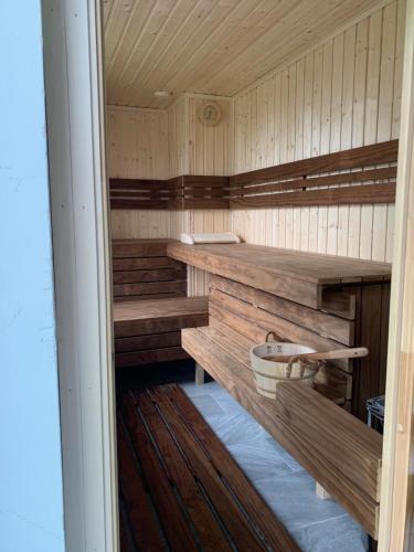 una sauna de madera con bancos y una cesta. en City panzió, en Balatonlelle