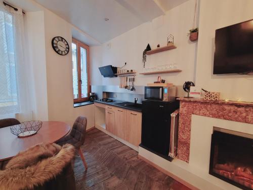 un salon avec une table et une cheminée dans l'établissement Appartement au cœur de ville, à Embrun