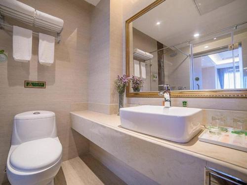 a bathroom with a sink and a toilet and a mirror at Vienna Hotel Hebei Qinhuangdao Hebei Street Taiyangcheng in Qinhuangdao