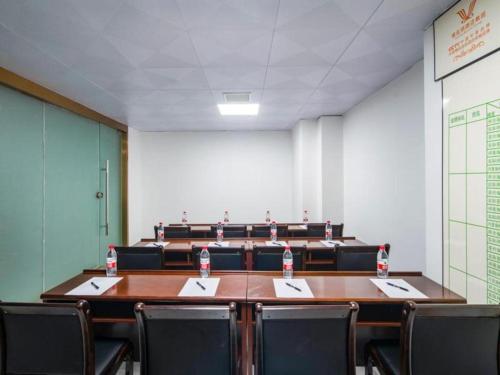 una sala de conferencias con mesa y sillas y botellas de agua en Vienna Hotel Kunming Dianzhong New District en Yanglin