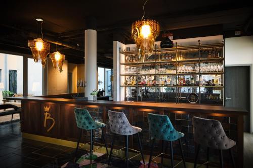 a bar with four stools in front of a counter at Hotel BalthazarS in Seligenstadt