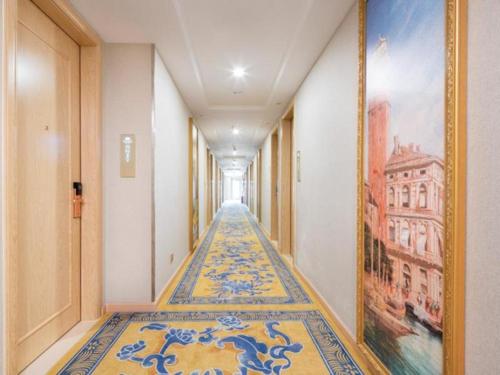 korytarz z niebieskimi i żółtymi kafelkami na podłodze w obiekcie Vienna Hotel Guangxi Hechi Jinchengjiang Baima Street w mieście Hechi