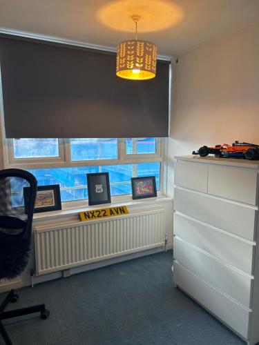 a room with a window and a desk with pictures at Hermitage Court in London