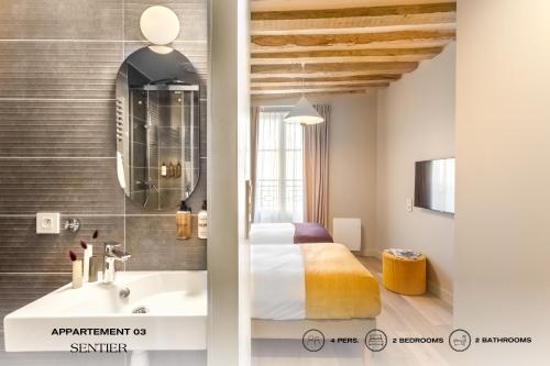 1 dormitorio con cama, lavabo y espejo en Beauquartier - Sentier, en París