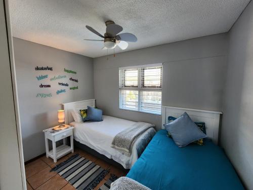 a bedroom with two beds and a ceiling fan at Beautiful Seaview Apartment! 48 De Valle Diaz Mosselbay in Mossel Bay