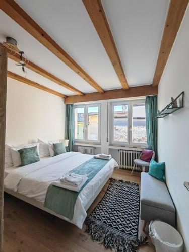 a bedroom with a large bed and a chair at City Apartment 221 in Merano