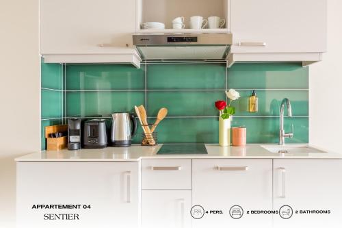 une cuisine avec des placards blancs et du carrelage vert dans l'établissement Beauquartier - Sentier, à Paris