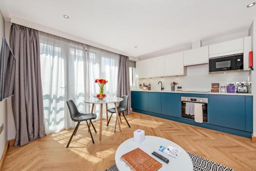 a kitchen and a living room with a table and chairs at Farringdon Serviced Apartments in London