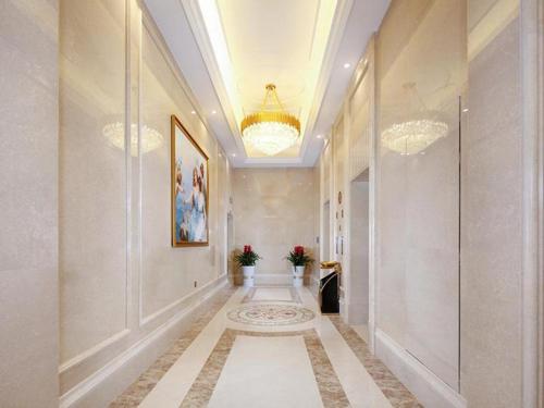 a hallway with two chandeliers and a long hallway with at Vienna Hotel Baoshan Yongchang Road in Baoshan