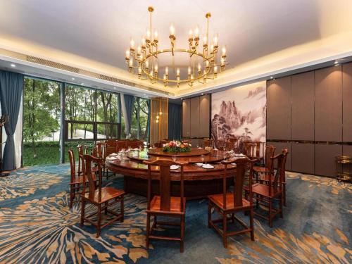 a dining room with a table and chairs and a chandelier at Venus Royal Hotel Nanning East High-Speed Railway Station in Nanning