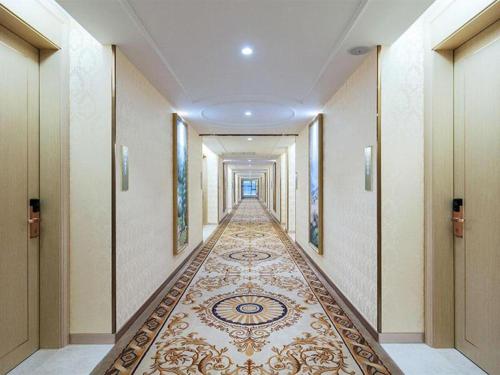 korytarz z podłogą wyłożoną kafelkami w hotelu z korridorngthngthngthngthngth w obiekcie Vienna Hotel Zhejiang Quzhou Jianglang Mountain Scenic Area Xiakou w mieście Nantang