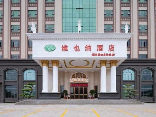 ein großes Gebäude mit einem Schild davor in der Unterkunft Vienna Hotel Guangdong Chaozhou Chaoshan High-Speed Railway Station in Denggang