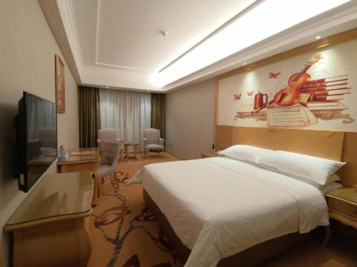 a hotel room with a large bed and a television at Vienna Hotel Guangdong Chaozhou Chaoshan High-Speed Railway Station in Denggang