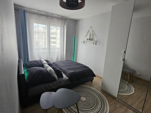 um quarto com uma cama em frente a uma janela em Chambre d'hôte - hypercentre em Annemasse