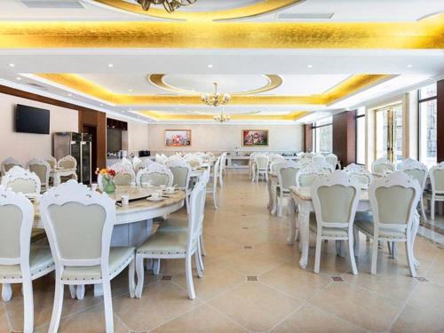 einen Bankettsaal mit weißen Tischen und Stühlen in der Unterkunft Vienna Hotel Jiangxi Fuzhou Lichuan Kangshu in Lichuan