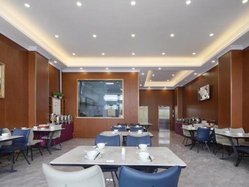 una sala da pranzo con tavoli e sedie di Vienna Hotel Qinghai Dachaidan a Da Qaidam