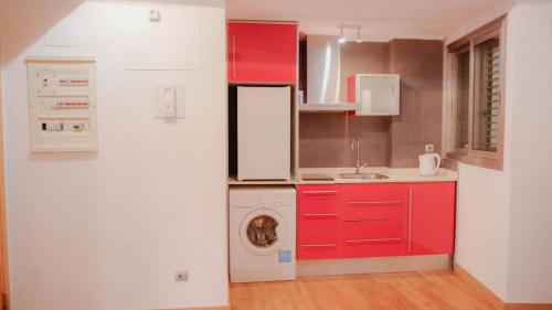 cocina con armarios rojos y lavadora en APARTMENTS LA LONJA DE LA SEDA, en Valencia