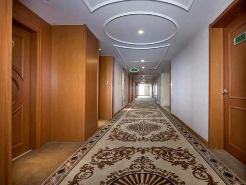 een hal met een lang tapijt in een gebouw bij Vienna Hotel Hohhot Zhaojun Road in Hohhot