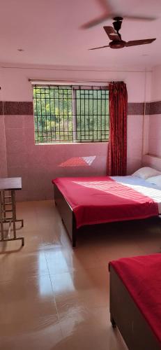 1 dormitorio con 2 camas y ventana en TT nalin inn, en Yercaud