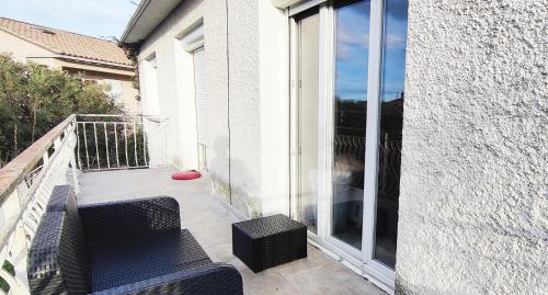 d'un balcon avec deux chaises et une porte coulissante en verre. dans l'établissement Appartement proche mer et centre historique, à Vendargues