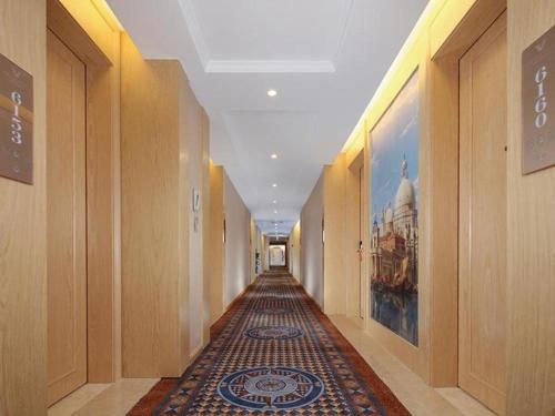 an empty hallway with a rug in a building at Vienna Hotel Wuhan Erqi Changjiang Bridge Yujiatou in Jiang'an