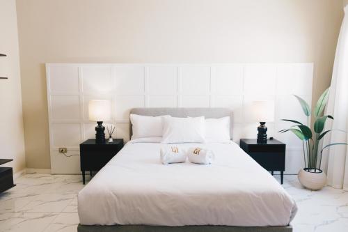 a bedroom with a large white bed with two night stands at VIDA by Elegant Hospitality in Cairo