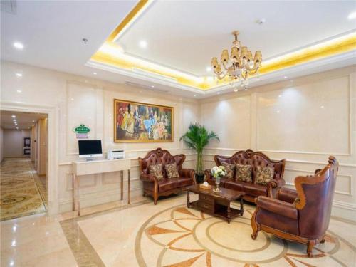 a living room with leather furniture and a chandelier at Vienna Hotel Tianjin Zhongbei Town in Caozhuang