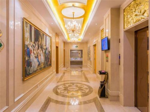 a hallway in a building with a painting on the wall at Vienna Hotel Tianjin Zhongbei Town in Caozhuang