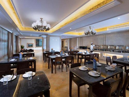 Vienna Hotel Fujian Yong'an South Railway Station في Yong'an: غرفة طعام مع طاولات وكراسي في مطعم