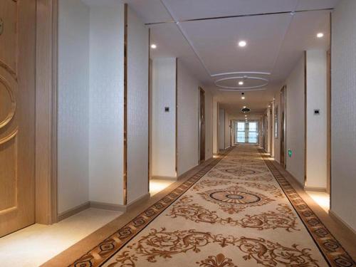 an empty corridor with a carpet in a building at Vienna Hotel Fujian Yong'an South Railway Station in Yong'an