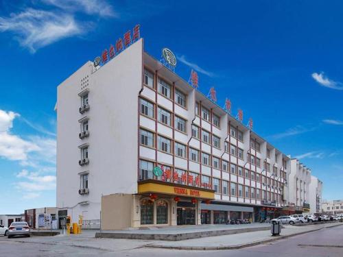 ein großes weißes Gebäude mit einem Schild drauf in der Unterkunft Vienna Hotel Xinjiang Kashgar 2nd Ring Road Food Street in Kashgar