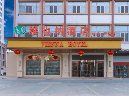 ein Hotel mit einem Schild auf der Vorderseite in der Unterkunft Vienna Hotel Xinjiang Kashgar 2nd Ring Road Food Street in Kashgar