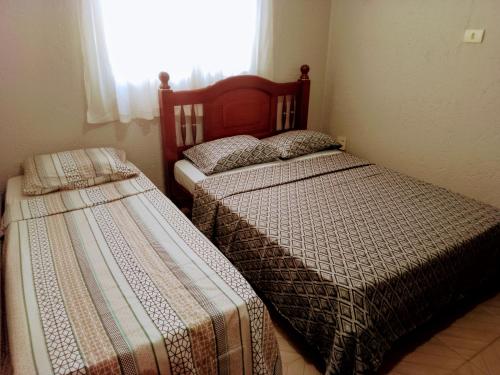 1 Schlafzimmer mit 2 Betten und einem Fenster in der Unterkunft Chácara a 6km do centro! in Poços de Caldas
