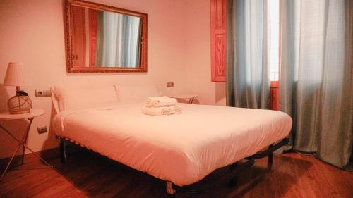 1 dormitorio con cama blanca y espejo en APARTMENTS LA LONJA DE LA SEDA, en Valencia
