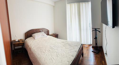 Schlafzimmer mit einem Bett und einem Flachbild-TV in der Unterkunft Smart Room in La Paz