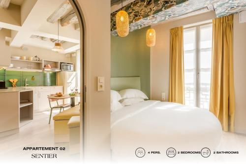 1 dormitorio con 1 cama blanca y cocina en Beauquartier - Sentier, en París