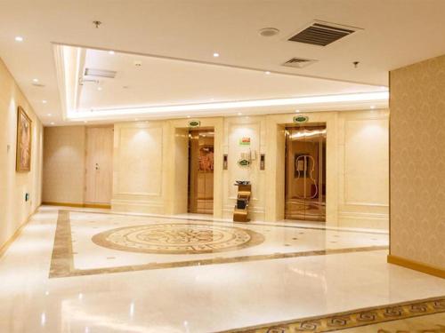 um grande átrio com um grande tapete no chão em Vienna Hotel Jilin Huichun Yadu Huayuan em Hunchun
