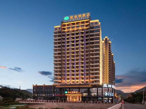 Un grand bâtiment avec un panneau en haut dans l'établissement Vienna Hotel Guangdong Chaozhou Fenghuang New City, 