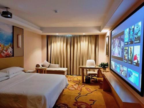 une chambre d'hôtel avec un lit et une télévision grand écran dans l'établissement Vienna Hotel Guangdong Chaozhou Fenghuang New City, 