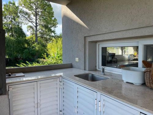 eine Küche mit einem Waschbecken und einem großen Fenster in der Unterkunft Casa Quinta Moderna - Country Golf in Gualeguaychú