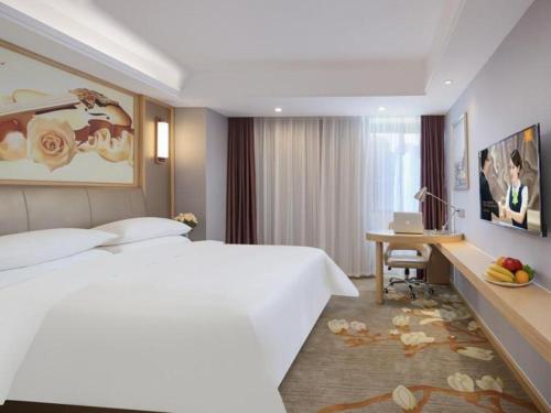 合肥市にあるVienna Hotel Hefei Railway Station Yuanyi Times Plazaの白い大型ベッド1台、デスクが備わる客室です。