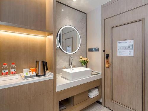 Huantuo的住宿－Vienna Hotel Tianjin Jinzhong Street，一间带水槽和镜子的浴室