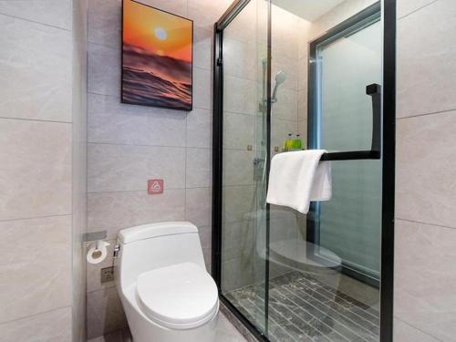 Vienna Hotel Tianjin Jinzhong Street في Huantuo: حمام مع مرحاض ودش زجاجي